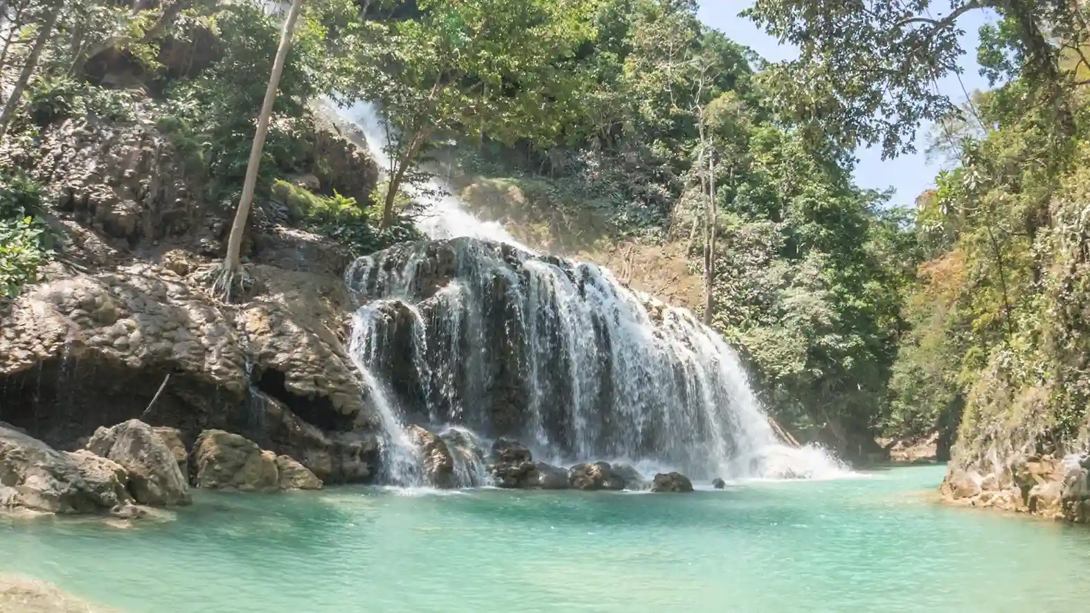 Lapopu Waterfall cascading into a green pool